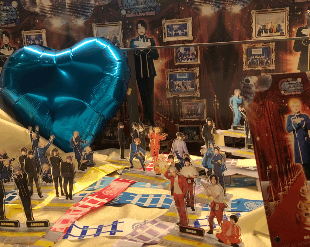 A display of Aoharu Tetsudo characters arranged with JR railway line colors, oshi-color accessories, and Shinkansen-themed palettes at the 10th Anniversary Live. A visual example of Japanese oshi culture and color-based fandom expression.