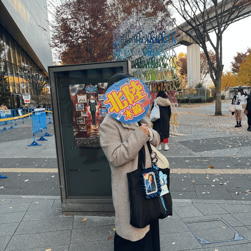 A fan expressing their oshi color through railway-themed accessories at the Aoharu Tetsudo 10th Anniversary Live, showing Japanese oshi culture in everyday fashion.