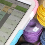 inventory management workspace with tablet and handmade product stock for an Etsy shop